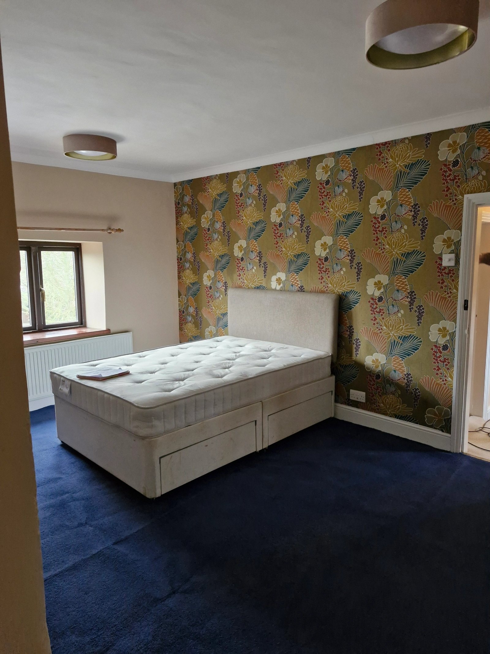 Bedroom with patterned feature wallpaper and a flush ceiling light fitting