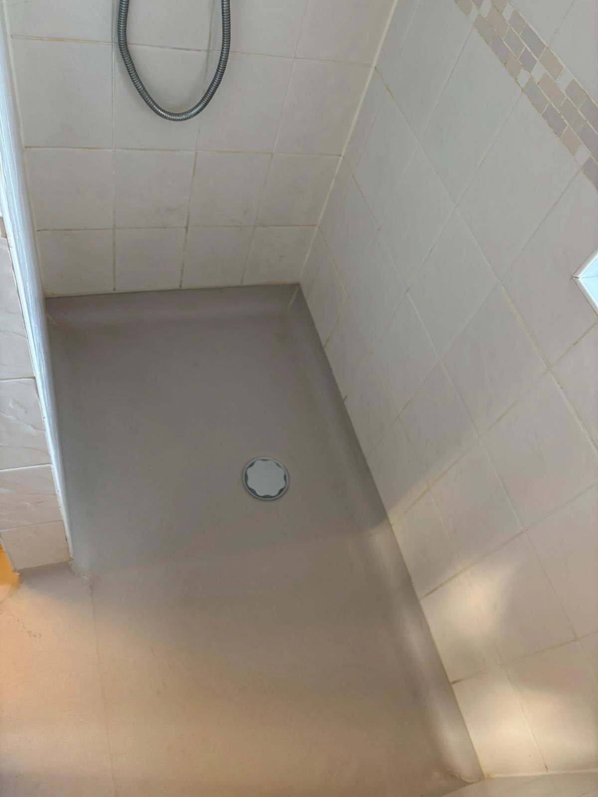 Tiled shower enclosure with a low-profile tray and central waste