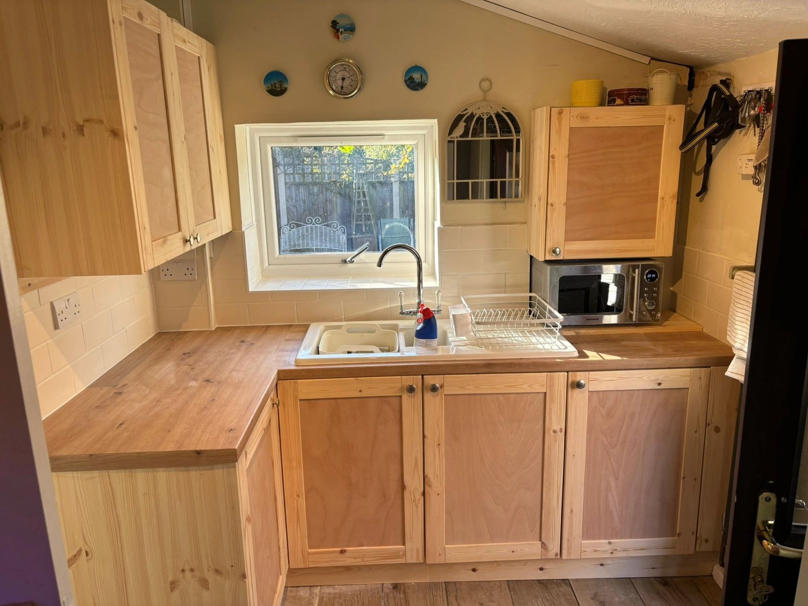 Corner of a fitted timber kitchen with wall cupboards and worktop